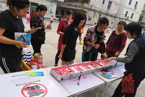 图为禁毒社工向来往群众讲解禁毒知识